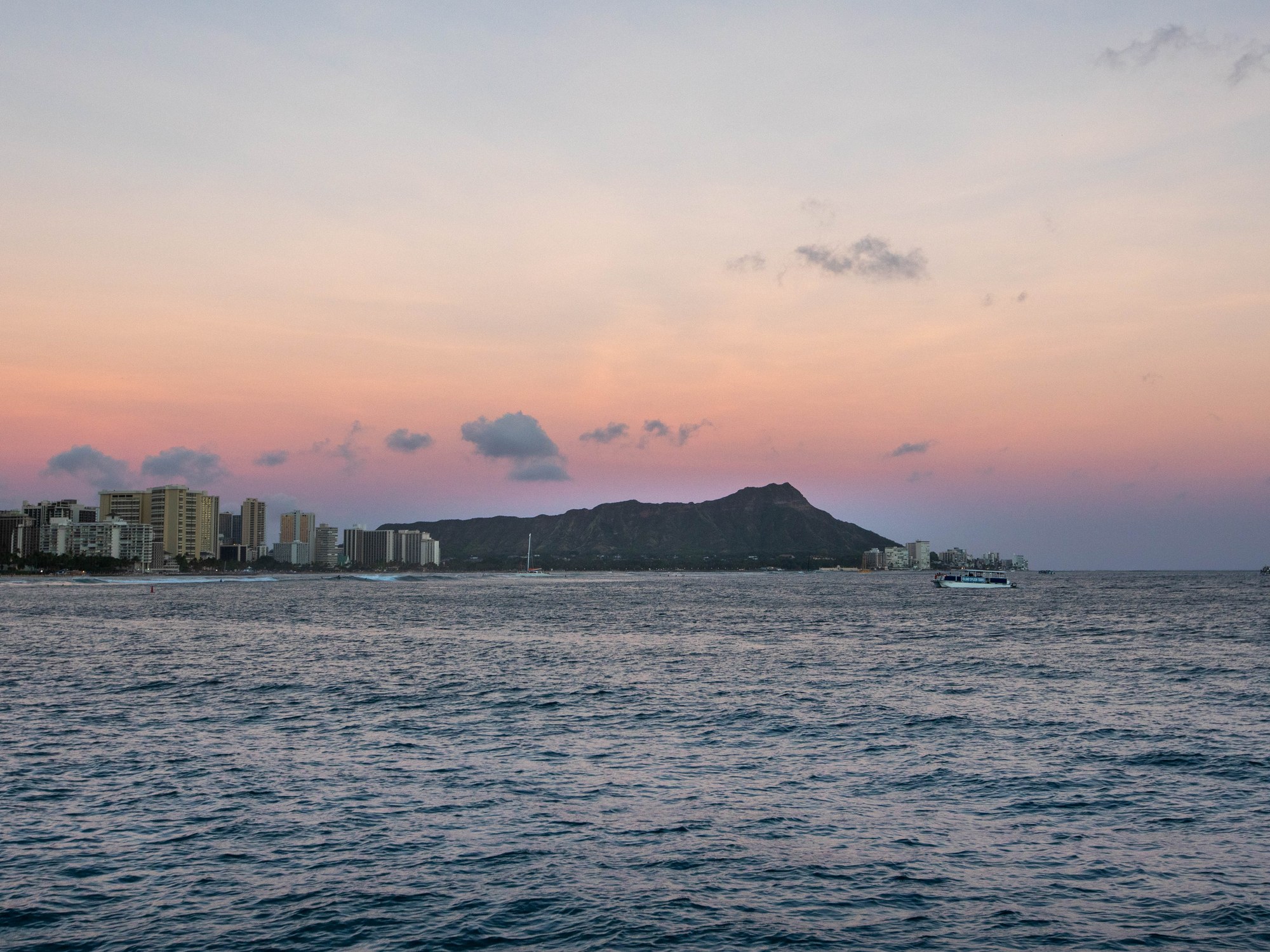 Guests aboard Illuminate at dusk near Waikīkī
